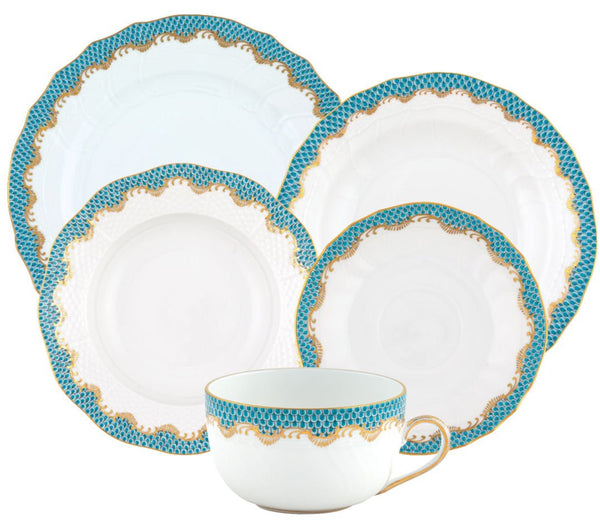 The Herend Fish Scale Turquoise Collection by Herend features a set of five ceramic dishes with teal and gold patterned rims, showcasing intricate hand-painted designs. This collection includes plates of various sizes and a teacup, perfect for those with an artistic appreciation.