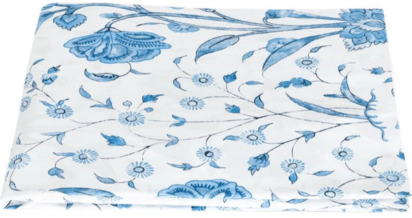 A folded white fabric made from luxurious Egyptian cotton percale with a blue floral and leaf pattern, spread out on a flat surface from the Matouk Schumacher Khilana Bedding Collection, Azure by Matouk.