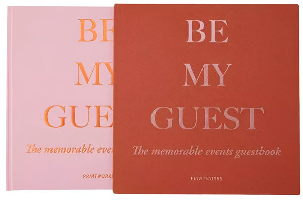 Two Guest Books titled "PrintWorks Be My Guest Book, Rust and Pink" by PrintWorks are displayed side by side, capturing cherished memories with their elegant design.