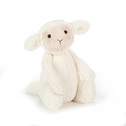 A soft, plush Jellycat Bashful Lamb, Medium with creamy fur, long floppy ears, and black eyes sits as a cuddly toy against a plain white background.