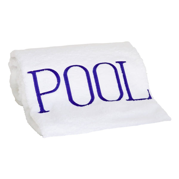 A rolled-up white cotton terry towel by Hamburg House, embroidered with the word "POOL" in marine blue letters, making it the perfect poolside accessory.