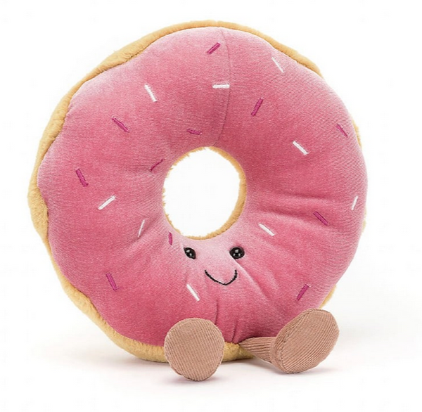 A Jellycat Amuseable Doughnut plush toy shaped like a donut with berry-pink icing, rainbow sprinkles, a smiling face, and small brown feet.