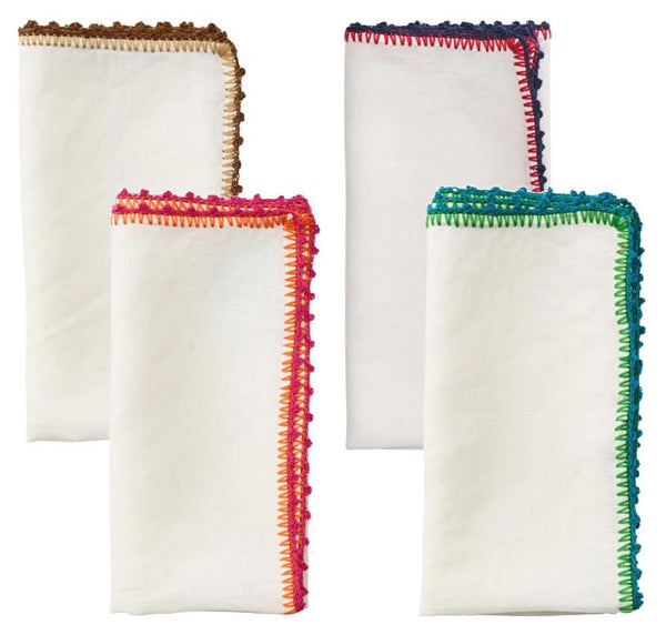 The Kim Seybert Knotted Edge Napkin set of four by Kim Seybert features white linen napkins with vibrant hand-crocheted edging in brown, blue, red, and green.