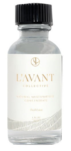 A clear eco-luxe glass bottle with a black cap labeled "L'Avant Collective L'Avant Multipurpose Concentrate Refill Fresh Linen" and containing 2 fluid ounces of liquid, crafted with plant-based ingredients.