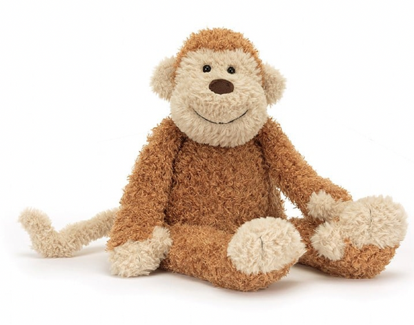 A fluffy stuffed Jellycat Junglie Monkey with tan and cream fur, featuring soft golden accents, is sitting with its legs stretched out in front. It's irresistibly cuddly, perfect for snuggles.