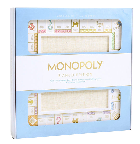 A boxed WS Game Company Monopoly Bianco Edition board game features pastel-colored property spaces. The packaging showcases a "foil-stamped premium game board," a "wood-framed rolling area," and "premium components" including die-cast tokens.