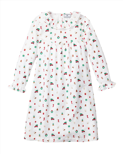 The Petite Plume Winter Nostalgia Children's Scarlett Nightgown is a white long-sleeved dress that features a nostalgic holiday print with stockings, trees, ornaments, and gifts, perfectly reminiscent of a classic Scarlett nightgown.