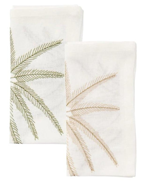 A set of four Kim Seybert Palm Coast Napkins, each crafted from white linen and featuring embroidered palm fronds in green and beige, displayed on a white background.