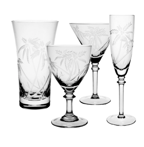 The William Yeoward Crystal Palmyra Collection by William Yeoward Crystal features a set of four clear glassware pieces, including a tumbler, a goblet, a wine glass, and a champagne flute, each adorned with an etched palm tree pattern reminiscent of the serene beauty of Palmyra Atoll's pristine coral reefs.