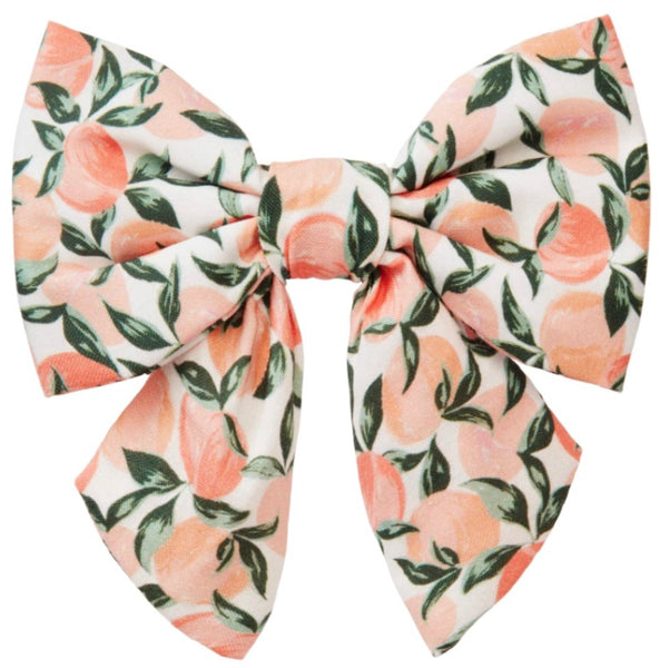 Introducing the Foggy Dog Lady Dog Bow, Peaches and Cream by Foggy Dog: a charming fabric bow adorned with a hand-illustrated pattern of peaches and green leaves set against a white backdrop.