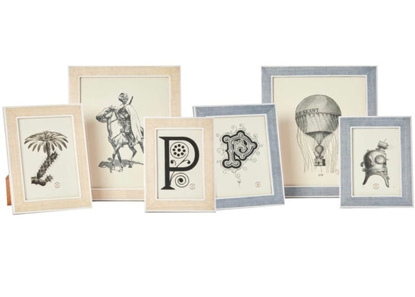 The Pigeon & Poodle Aberdeen Frame Collection by Pigeon & Poodle is a set of six framed prints of vintage illustrations, featuring designs such as a hot air balloon, a diver, a palm tree, and ornate letter motifs. The frames are crafted from Narra veneer wood in neutral-colored hues.