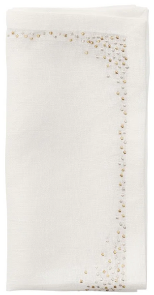 The Kim Seybert Pin Dot Napkin by Kim Seybert showcases a classic design, featuring small gold and silver pin dot embroidery along the edges of a folded white linen napkin.