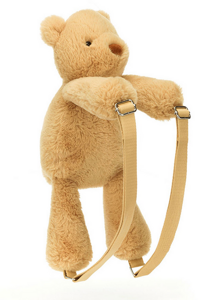 A plush, beige teddy bear with adjustable straps, resembling a Jellycat Smudge Bear Backpack by Jellycat, is shown against a white background.