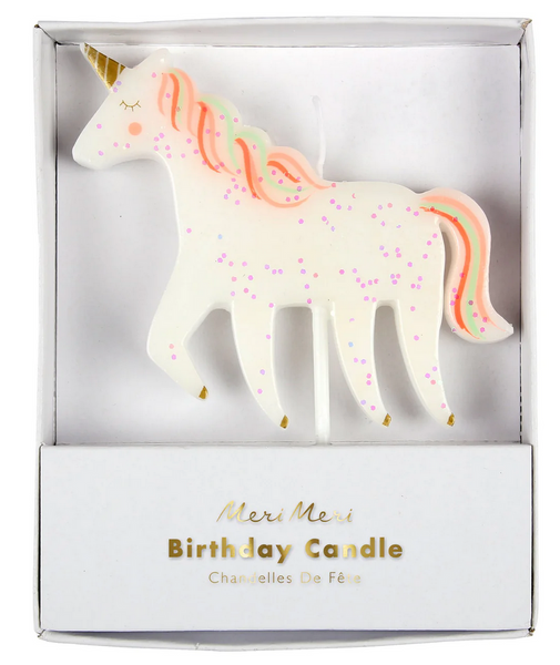 The Meri Meri Unicorn Glitter Candle, a white unicorn with pink hair, golden hooves, and multicolored spots, is packaged in a box labeled "Meri Meri Birthday Candle." This sparkling unicorn candle makes the perfect party cake decoration.