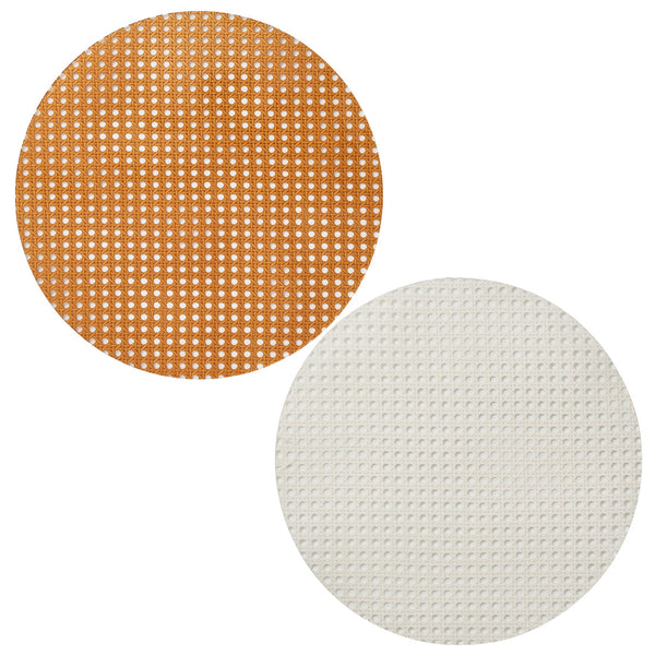 Two round textured pads, one brown and one white, displayed side by side on a plain background, evoke the charm of outdoor entertaining. These Kim Seybert Reed Placemats are perfect for adding a touch of rustic elegance to any setting.