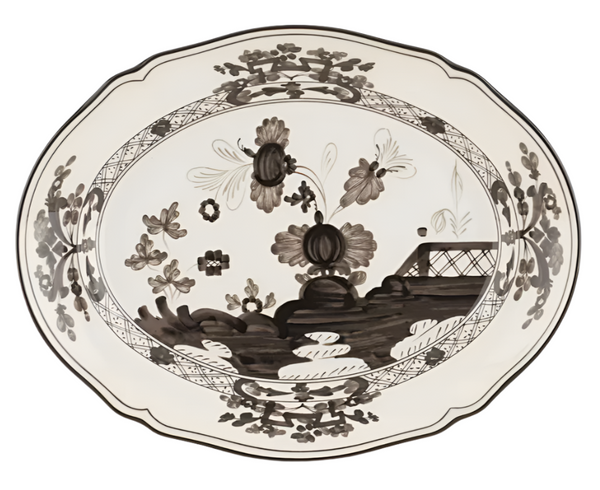 The GINORI 1735 Oriente Italiano Albus Oval Platter by Ginori 1735 is a ceramic plate adorned with a black and white floral pattern, featuring large central flowers and an ornate border design. Inspired by the classic Antico Doccia collection, this piece evokes the timeless elegance of Garofano motifs.