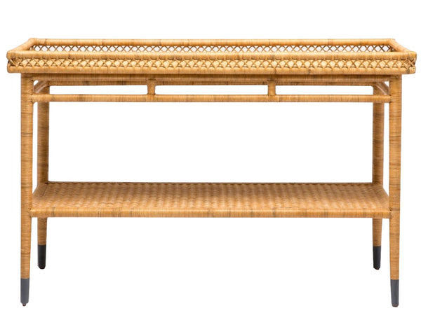 A rectangular console table from the Sarah Rattan Console Collection by Made Goods, featuring a detailed upper border and lower shelf. Its tightly woven rattan adds durability and style, while four legs with dark-colored tips support the structure.