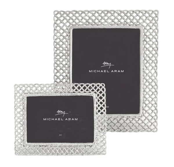 Two photo frames from the Michael Aram Love Knot Frame Collection symbolize the strength of togetherness. These silver-toned frames, one larger than the other, each hold a rectangular photo.