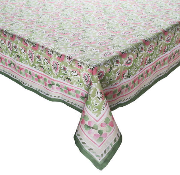 A luxurious Kim Seybert Mira Tablecloth, adorned in a blend of green, pink, and white with vibrant hand-painted paisley and geometric designs, elegantly covers the rectangular table—perfect for garden parties.