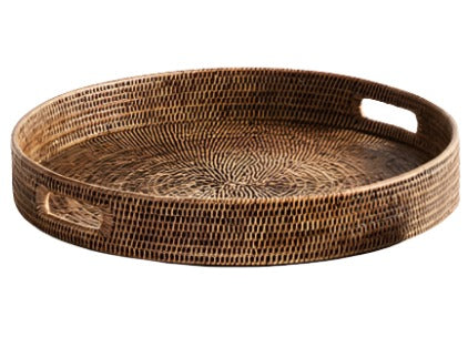 The Burma Rattan Round Ottoman Tray Collection by Napa Home & Garden, featuring raised edges and two cutout handles, adds a touch of sophistication to your luxurious home decor.