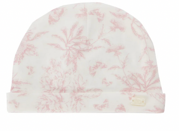 The Tartine et Chocolat Toile Rose Pale Beanie by Tartine et Chocolat is a white beanie adorned with a light pink floral pattern, reminiscent of Toile de Jouy, and features a small rectangular tag on the hem.