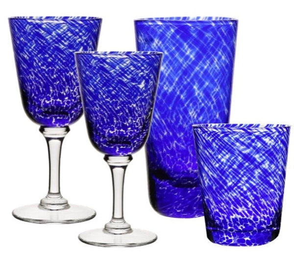 Set of four blue etched drinking glasses from the William Yeoward Crystal Vanessa Blue Collection, featuring two wine glasses with clear stems, one tall glass, and one short tumbler. The intricate designs create an optical illusion that adds a touch of mystique to any table setting.