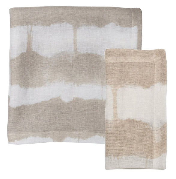 Two folded napkins from the Kim Seybert Watercolor Stripe Linen Collection in white and natural hues rest elegantly on a plain background, offering an artistic flair ideal for enhancing your summer dining table.