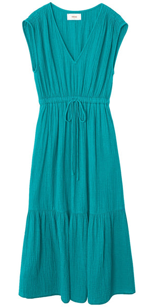 The Xirena Rosalie Dress by Xirena is a sleeveless maxi dress in a beautiful teal color, featuring a V-neck and an elasticized drawstring waist. It showcases a flared, tiered skirt crafted from airy cotton gauze for both comfort and style.