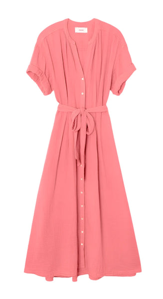 The Xirena Cate Dress by Xirena is a pink button-down dress featuring short sleeves, a V-neck, an adjustable tie-belt at the waist, and handy side seam pockets.