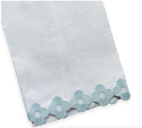 The Dolly Tip Towel, Blue by Haute Home is a stunning 14" x 20" white linen towel, adorned with delicate hand-embroidered light blue floral patterns that gracefully embellish the edges.