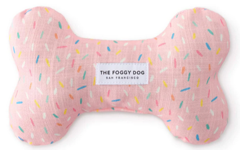 A Foggy Dog Dog Bone Squeaky Toy Collection in pink fabric with a colorful sprinkles design. Handcrafted and eco-friendly, it features a label in the center reading "Foggy Dog San Francisco.