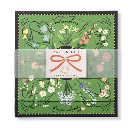 The Karen Adams 2025 Classic Desk Calendar Refill, featuring a vibrant floral design on a green background, arrives wrapped in a transparent band adorned with a ribbon illustration and the text "25 karen adams," and comes packaged in a custom envelope.