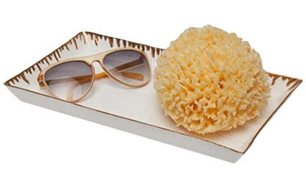 The Pigeon & Poodle Rio Tray, Gold Trim, elegantly holds beige sunglasses and a yellow sea sponge, making it a perfect addition to your home decor.