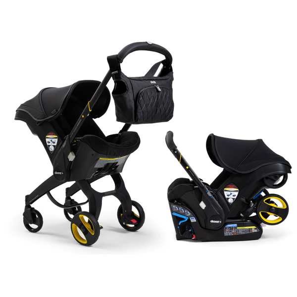 A Doona Car Seat and Stroller from the Midnight Edition, featuring a black design with yellow accents, is shown with a matching detachable infant car seat. A black quilted diaper bag is attached to the stroller handle.