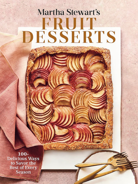 The cover of the Penguin Random House book, "Martha Stewart's Fruit Desserts," features a delectable berry tart accompanied by three gold forks and a folded pink and red napkin on a white backdrop, offering inviting desserts that highlight seasonal fruit recipes.