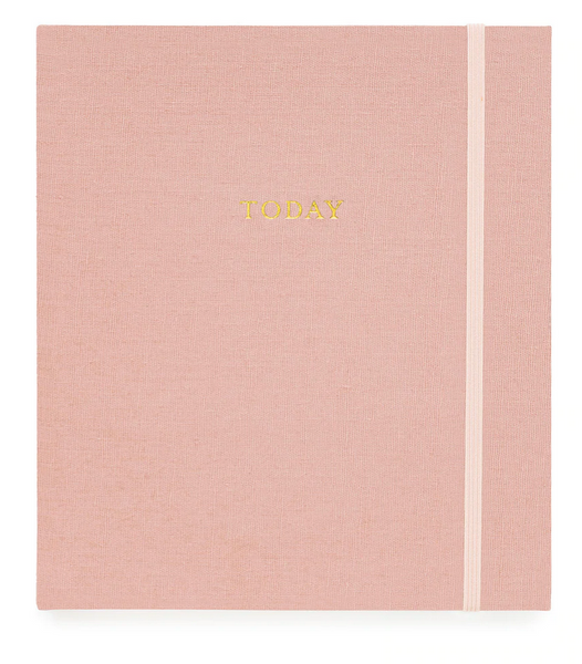 A pink fabric-covered journal with the word "Today" written in gold letters on the cover and a light pink elastic band on the right side—Sugar Paper's The Mindful Journal, Pink—a perfect companion for boosting daily productivity and recording your journey to happiness.