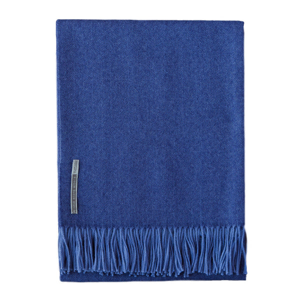 A Alicia Adams Alpaca Classic Throw, Indigo Herringbone with fringes on it.