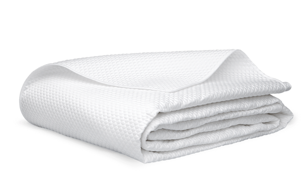 A Matouk Alba Bedding Collection, White, made from OEKO-TEX Standard 100 certified materials, neatly folded on a white background.