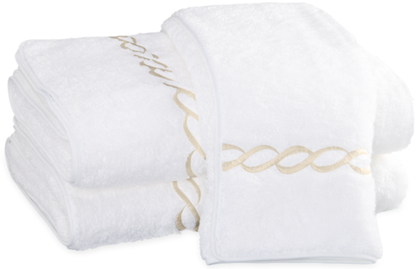 A set of neatly folded Matouk Classic Chain Bath Collection - Ivory with gold embroidery, crafted from long-staple cotton and OEKO-TEX certified.