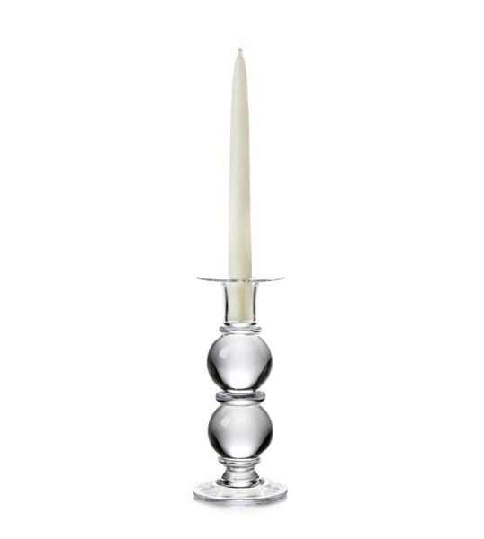 A handmade Simon Pearce Hartland Candlestick, Medium with a taper candle inside.