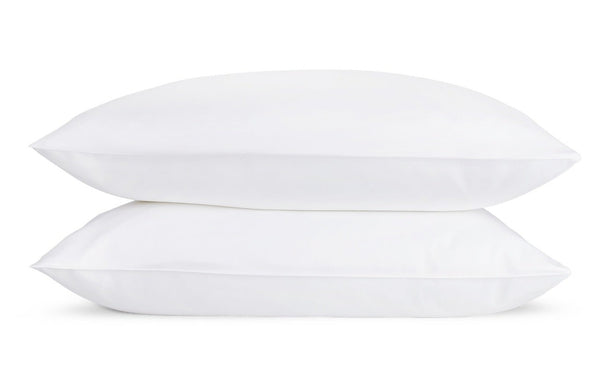 Two white, luxury Matouk Pillow Protectors stacked on top of each other against a plain white background, crafted from 300 thread count cotton sateen by Matouk.