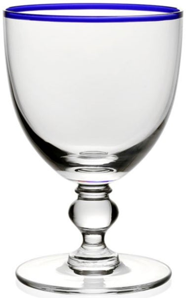 The William Yeoward Crystal Siena Water Glass, Blue from William Yeoward Crystal is a handmade water glass featuring a colorful rim around the top and a sturdy, decorative stem.