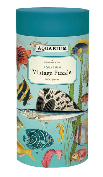 Cylindrical box containing a Cavallini Papers and Co. "Aquarium" 1,000-piece puzzle, featuring vibrant fish illustrations.