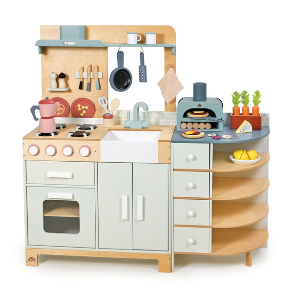 The Tenderleaf La Fiamma Grand Kitchen by Tender Leaf Toys comes with a complete wooden toy set featuring utensils, stove, sink, and shelves. It also includes a pizza oven, hanging pots and pans, a cutting board, mixer, and felt food such as pizza, vegetables, and fruits.