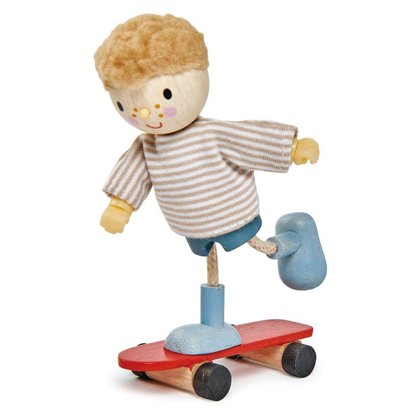 A Tenderleaf Edward & His Skateboard wooden figurine of a boy with blond hair riding a solid wood skateboard, isolated on a white background.