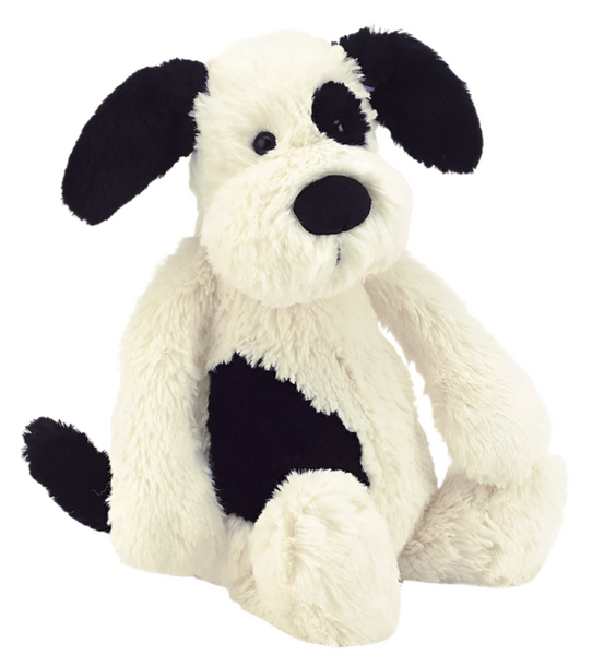  Jellycat black and white stuffed dog sitting on a white background.