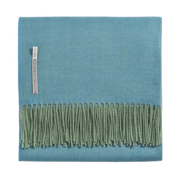 A folded Alicia Adams Alpaca Classic Throw, Turquoise Herringbone with green fringe on one edge and a small Alicia Adams Alpaca label.